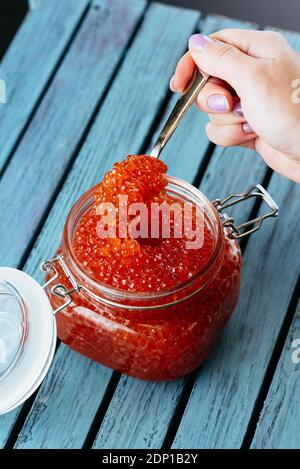 red caviar in a jar with a spoon Stock Photo