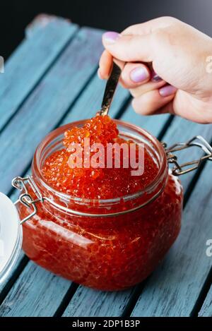 red caviar in a jar with a spoon Stock Photo