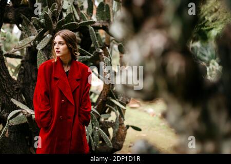 Woman with red coat in a park Stock Photo