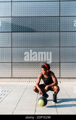 Spain, Madrid, Young athletic Afro man trainig with basketball ball in the city, Youth, Ethnicity, Connection, Sport Stock Photo
