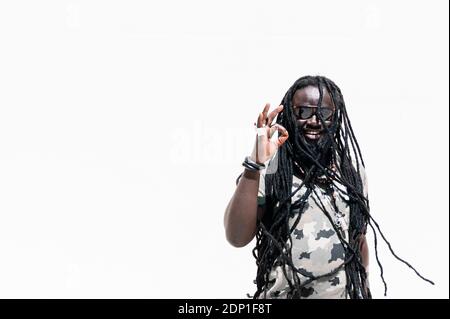 Smiling man with dreadlocks making positive hand sign Stock Photo