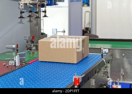 Cardboard Box at Modern Conveyor System in Factory Stock Photo