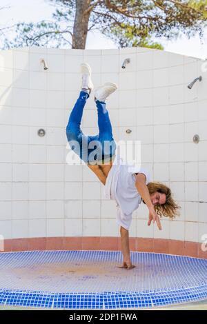 Young man doing handstand on one hand Stock Photo