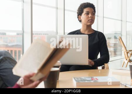 Woman using laptop in library Stock Photo