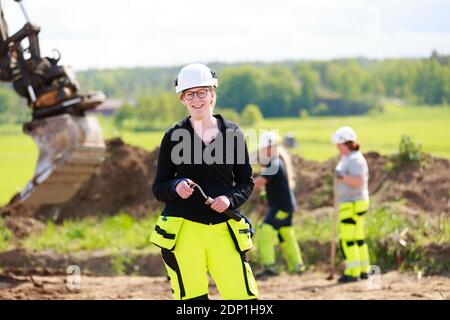 Female worker with digger on background Stock Photo