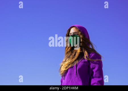 Girl wearing hoodie and face mask during Covid 19 pandemic