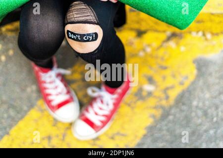 Close-up of band-aid on girl's injured knee Stock Photo