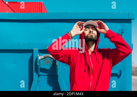 Young man wearing red hoodie, facing the sun Stock Photo