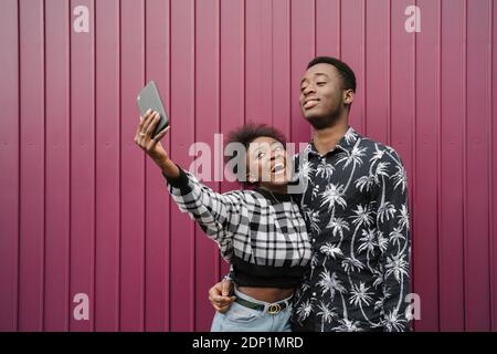 Portrait of young couple taking selfie with smartphone Stock Photo