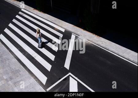 Top view of young woman with baggage crossing a street at the airport Stock Photo