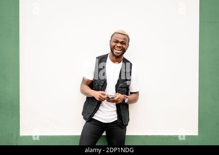 Man using smartphone in front of a green and white wall Stock Photo