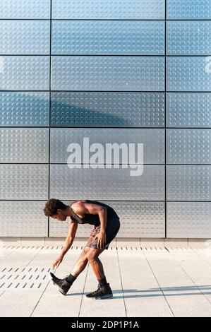 Spain, Madrid, Young athletic Afro manstretching in urban area, Youth, Ethnicity, Healthy, Sport Stock Photo