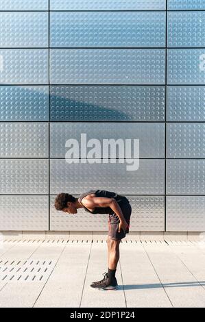 Spain, Madrid, Young athletic Afro manstretching in urban area, Youth, Ethnicity, Healthy, Sport Stock Photo