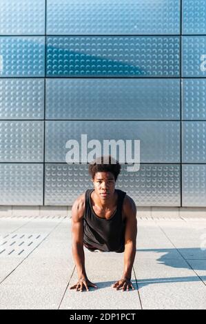 Spain, Madrid, Young athletic Afro man doing push ups in urban area, Youth, Ethnicity, Healthy, Sport Stock Photo