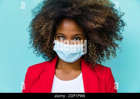 Woman wearing protective face mask standing against wall Stock Photo