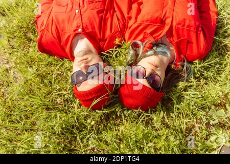 Portrait of young couple dressed in red lying on a meadow Stock Photo
