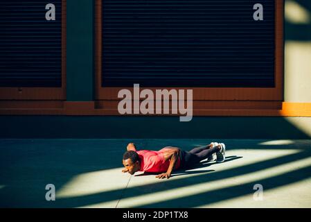 Young sportive man doing pushups outdoors Stock Photo