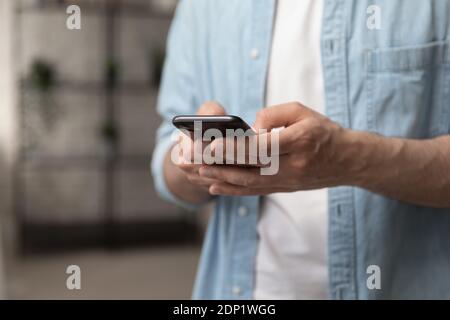 Male hands holding smartphone touching sensor screen browsing internet Stock Photo