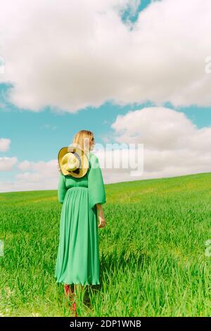 Back view of woman wearing green dress standing on a field Stock Photo ...