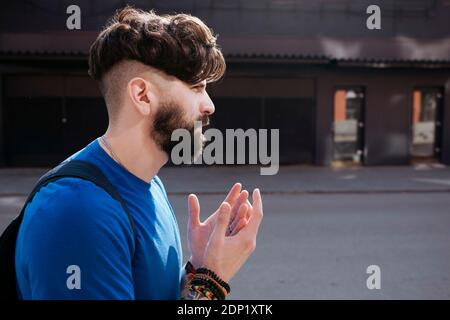 Young bearded man walking through the city Stock Photo