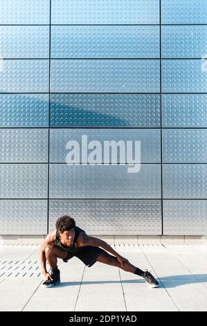 Spain, Madrid, Young athletic Afro manstretching in urban area, Youth, Ethnicity, Healthy, Sport Stock Photo
