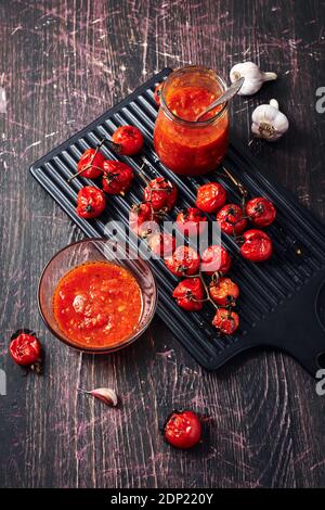 Tomato sauce and ingredients on a dark wooden background. Stock Photo