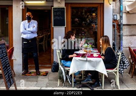 Two Women Enjoy A Meal At A Restaurant In The Cannaregio District, Venice, Italy. Stock Photo