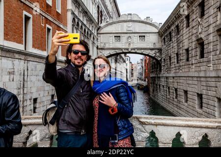 A Couple Taking A Selfie At The Bridge Of Sighs (Ponte Dei Sospiri), Venice, Italy. Stock Photo