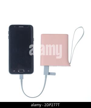 Modern smartphone charging from power bank isolated on white background. Gadgets for smartphones, external battery Stock Photo