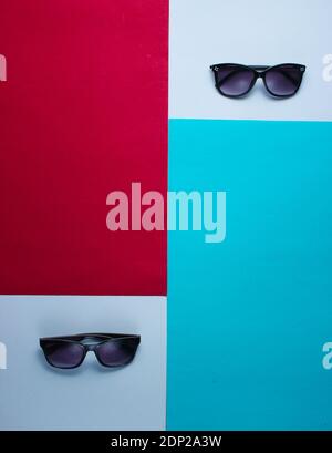 Two pairs of sunglasses on a colored paper background. Top view Stock Photo