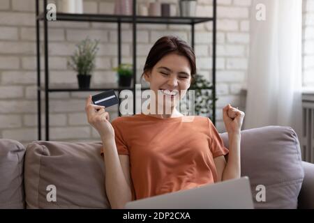 Happy millennial woman bank client satisfied with providing payment online Stock Photo