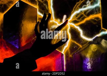 Woman hand touching plasma panel display in dark room of museum - close up view Stock Photo