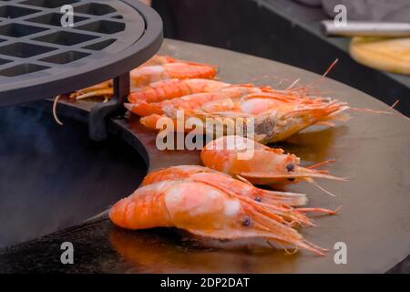 Process of grilling fresh red king prawns on brazier - close up view Stock Photo