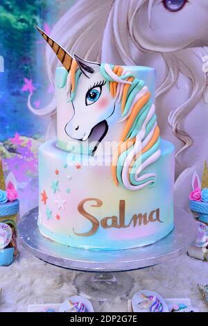 Pink birthday cake for girls.Detail of a birthday unicorn cake - focus on rainbow topper. Stock Photo