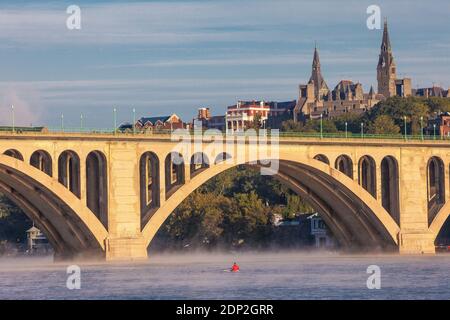 Early Morning Rower in Skiff on Potomac River, Key Bridge and Georgetown University in Background, Washington DC, USA. Stock Photo