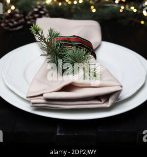 Christmas rustic home table with empty plate and xmas decor on blurry lights background. Closeup. Stock Photo