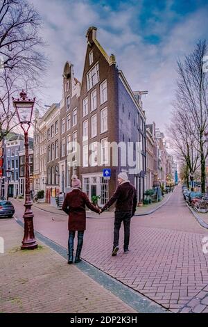 Amsterdam dutch canals , couple visit dutch canals during city trip in Amsterdam, men and woman on city trip in Amsterdam Netherlands. Europe Stock Photo