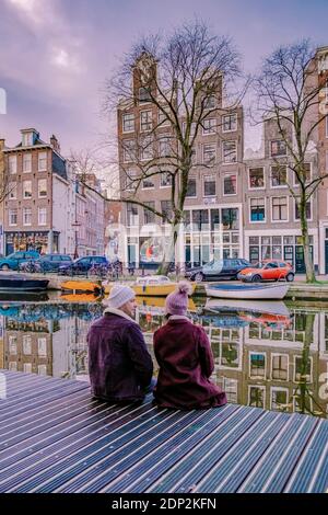 Amsterdam dutch canals , couple visit dutch canals during city trip in Amsterdam, men and woman on city trip in Amsterdam Netherlands. Europe Stock Photo