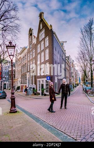 Amsterdam dutch canals , couple visit dutch canals during city trip in Amsterdam, men and woman on city trip in Amsterdam Netherlands. Europe Stock Photo