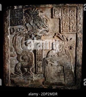 The Yaxchilan Lintels. Lintel 15. Structure 21. Carved limestone lintel with glyphs and a scene representing Lady Wak Tuun, during a bloodletting rite. She is carrying a basket with the paraphernalia used for auto-sacrifice: stingray spine, a rope and bloodied paper. The vision serpent appears before her springing from a bowl set before her which also contains strips of bark-paper. Late Classic Maya, 770. Limestone. Yaxchilan, Chiapas, Mexico. British Museum. London, England, United Kingdom. Stock Photo