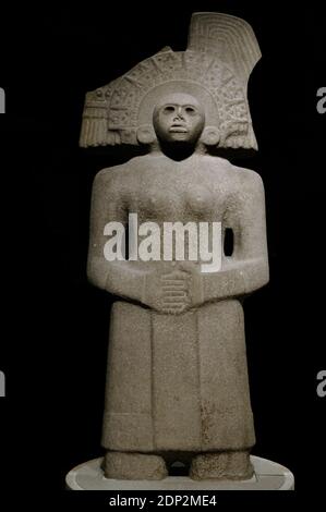 Pre-Columbian period. Huastec civilization (900-1450). Female figure depicting Tlazolteotl (Goddess of Fertility). Sandstone. Tlazolteotl is shown with her hands clasped in front, wearing semi-circular headdress with radiating 'spikes' and engraved design. Panuco river, Mexico. British Museum. London, England, United Kingdom. Stock Photo