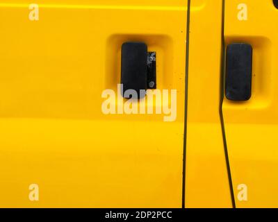 Abstract detail of yellow metallic panels, black handles and shut-lines on a van Stock Photo
