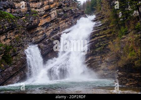 Waterfall cascading over diagonal rock layers. Stock Photo