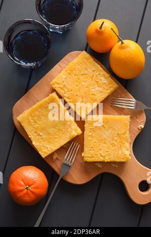 Healthy detox drinks and sweets. Organic Thai blue tea anchan with lemon pie and fresh fruits on dark background overhead view Stock Photo
