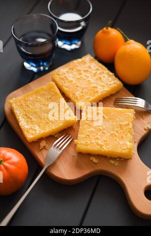 Healthy detox drinks and sweets. Organic Thai blue tea anchan with homemade lemon pie and fresh fruits on dark background vertical Stock Photo