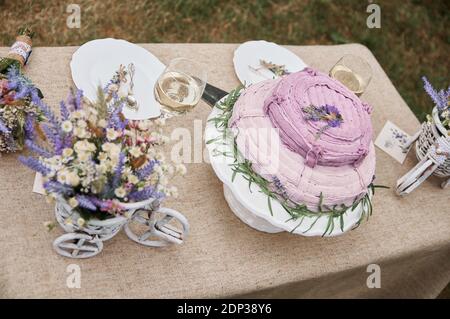boho style wedding cake on a table covered with a linen tablecloth Stock Photo