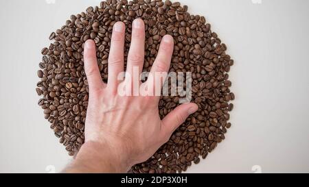 Fragrant roasted coffee beans. Roasted coffee beans background.Hand in coffee beans, top view, aromatic collected Stock Photo