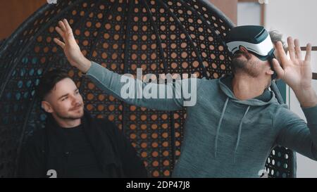 Happy gay couple testing the virtual reality glasses at home. High quality photo Stock Photo