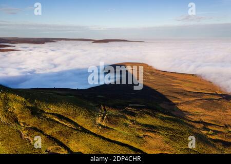 Aerial view of mountains rising above a sea of fog on a bright, sunny day. Stock Photo