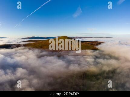 Aerial view of the Sugar Loaf mountain in the Brecon Beacons rising above a sea of cloud and fog. Stock Photo